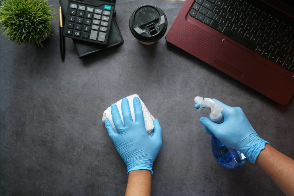 Limpiando un escritorio con guantes